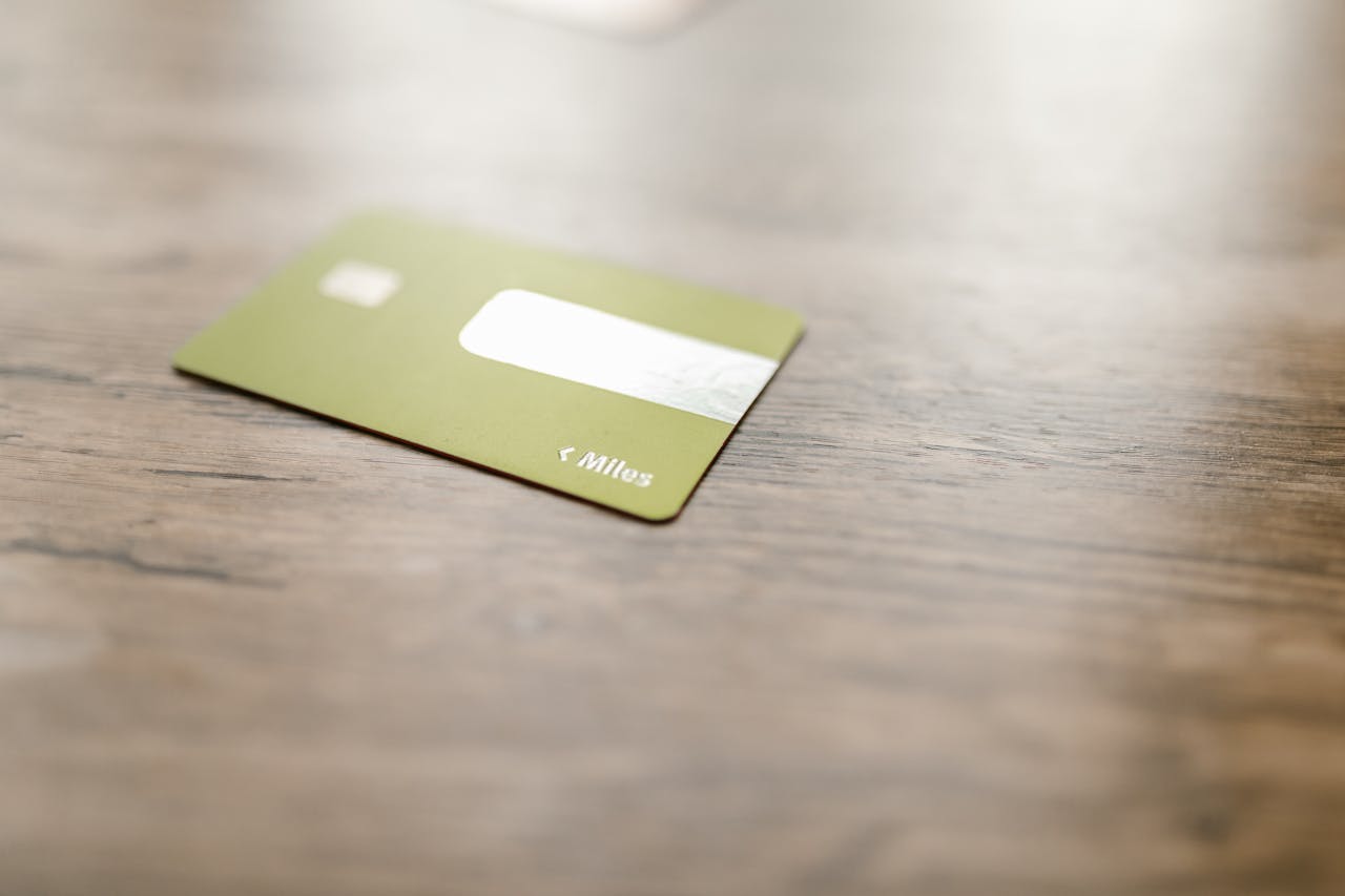 Green credit card placed on a wooden surface, captured with a blurred focus for a modern, minimalistic feel.